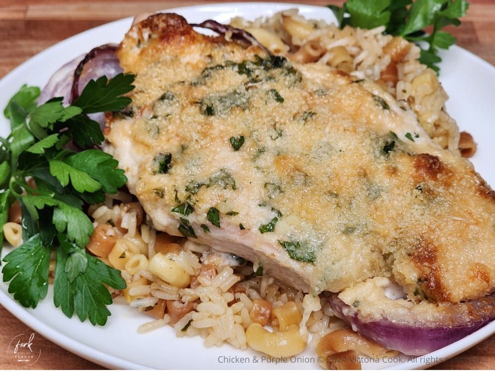 Baked Chicken & Purple Onion plated on a bed of homemade rice-a-roni and garnished with parsley