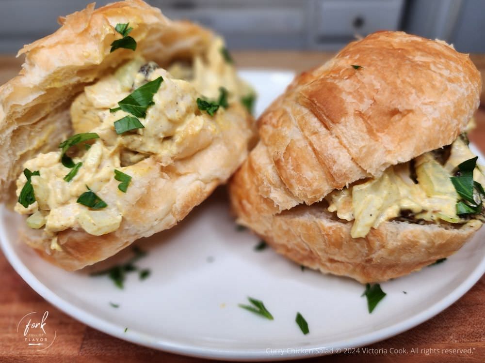 Two Curry Chicken Salad  sandwiches on croissants plated