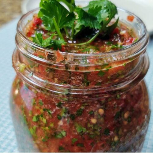 Fresh homemade salsa topped with a sprig of cilantro