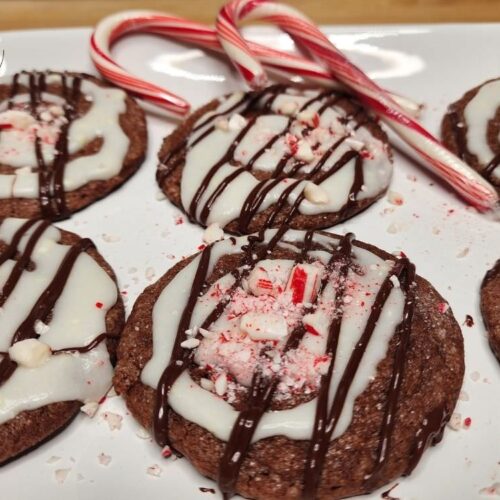 A plate of chocolate peppermint cookies on a plate with candy canes.