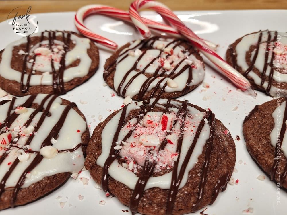 A plate of chocolate peppermint cookies on a plate with candy canes.